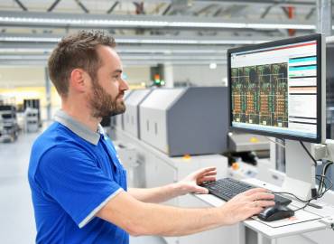 Homme devant un ordinateur dans une usine, illustrant le module gestion de production d'un ERP