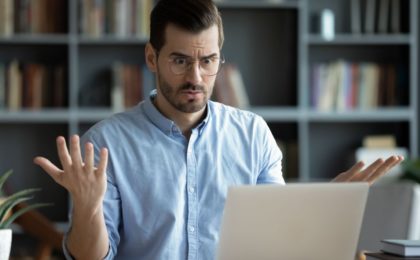 Homme énervé devant un ordinateur