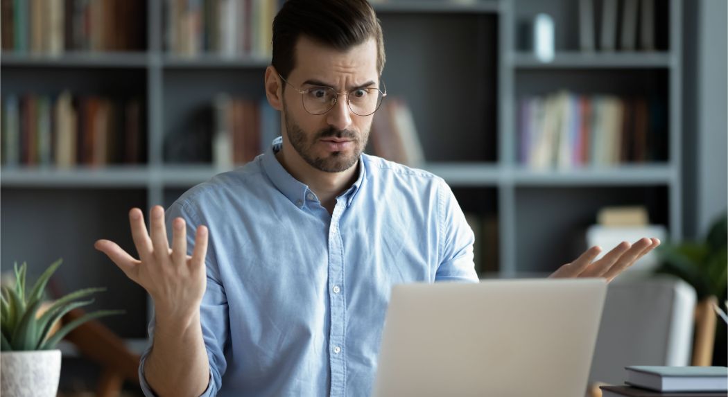 Homme énervé devant un ordinateur